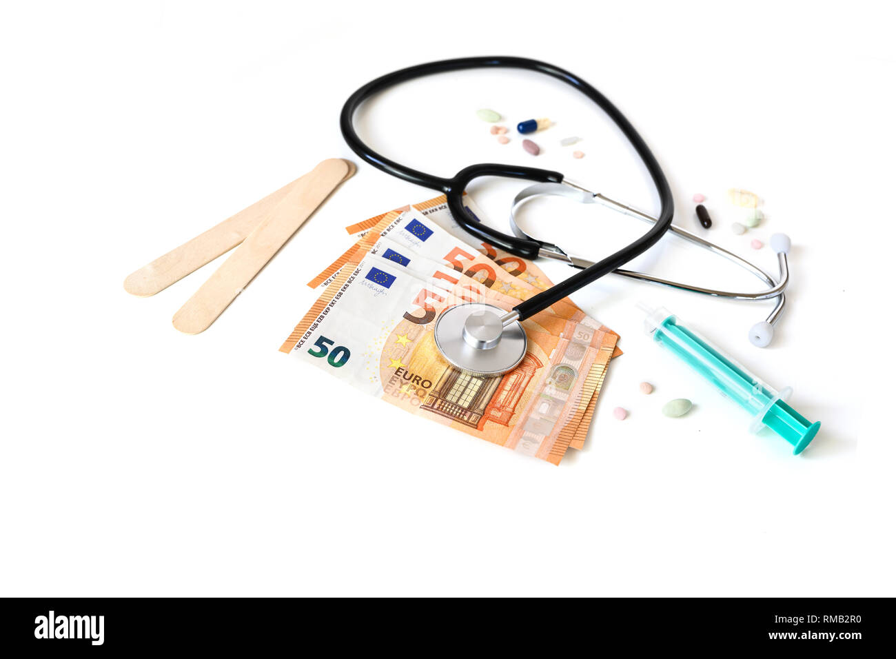 Stethoskop auf Euro Banknoten, Spritze und Pillen, die Kosten im Gesundheitswesen oder das finanzielle Risiko Konzept auf einen weißen Hintergrund mit Kopie Raum isoliert Stockfoto