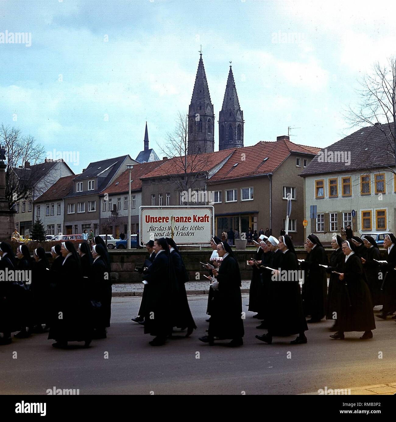 Palmsonntag Prozession der Katholiken vor einer Party Slogan in Heiligenstadt/Eichsfeld. Stockfoto