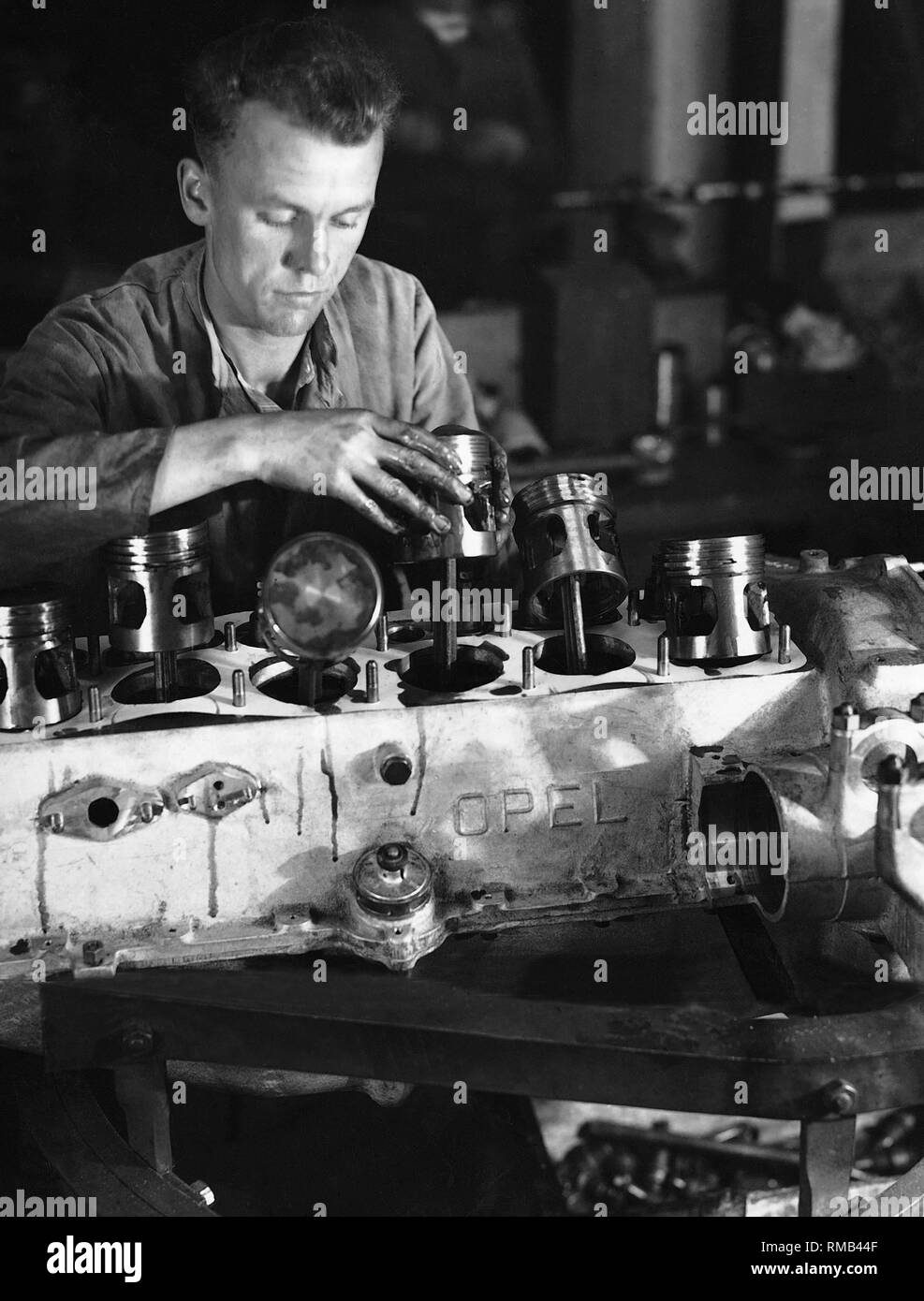 Ein Mechaniker fügt der Kolben in der kurzen Block von Opel. Stockfoto