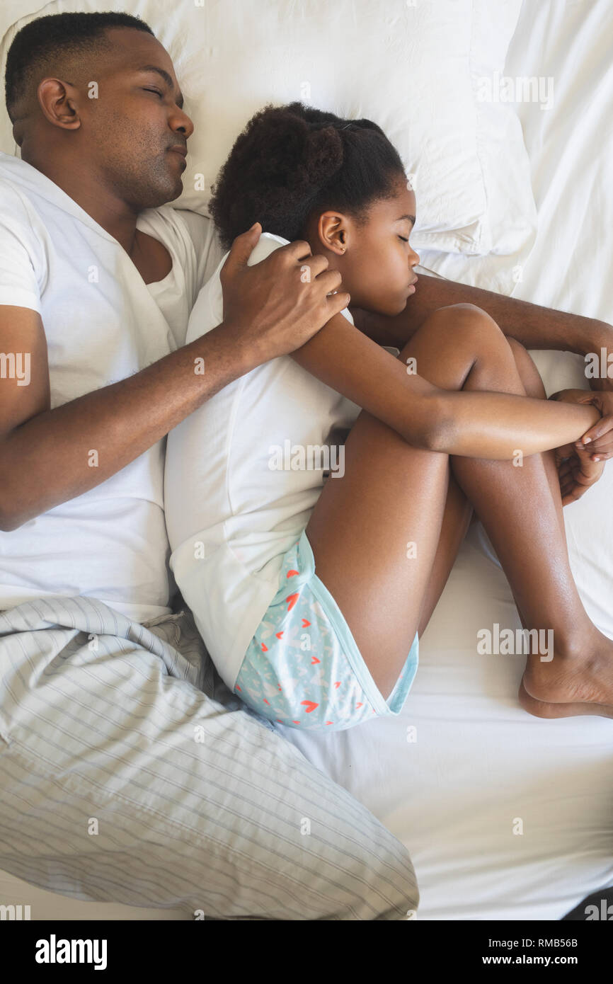 African American Vater und Tochter zusammen Schlafen auf dem Bett im Schlafzimmer Stockfoto