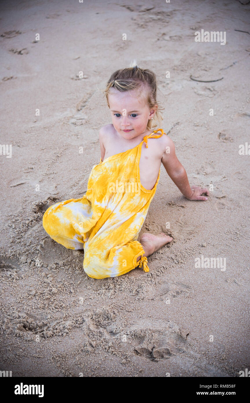 Kleine blonde Kind im sand sitzen Stockfoto