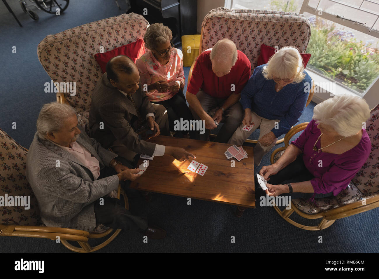 Gruppe von älteren Freunden Karten am Pflegeheim Stockfoto
