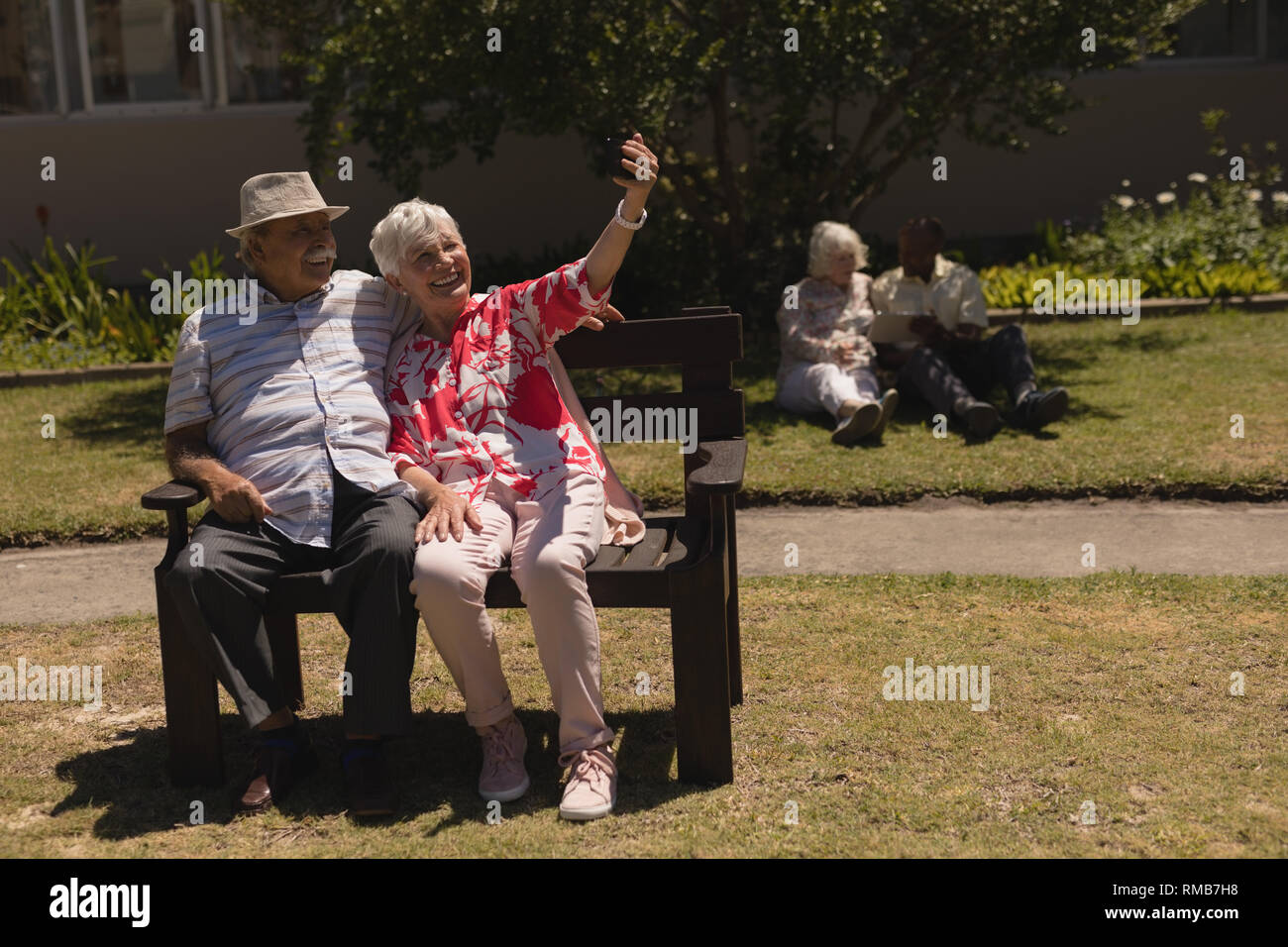 Vorderansicht des älteren Paares unter selfie mit Handy im Garten Stockfoto