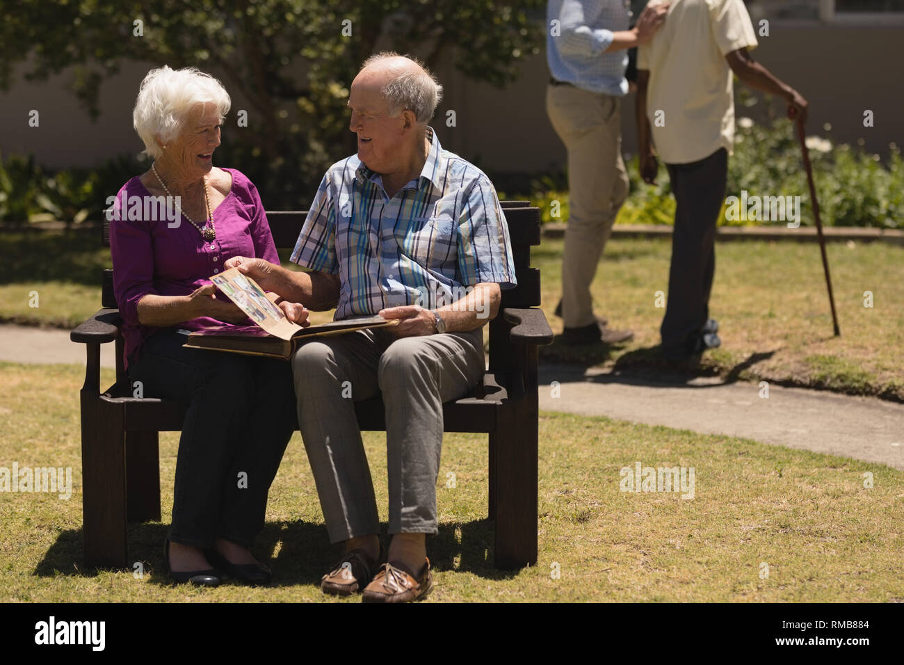 Senior Paar an Fotoalbum im Park Stockfoto