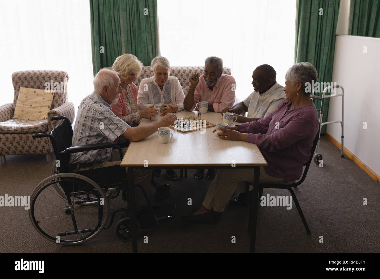 Gruppe von älteren Menschen Schach spielen im Wohnzimmer Stockfoto