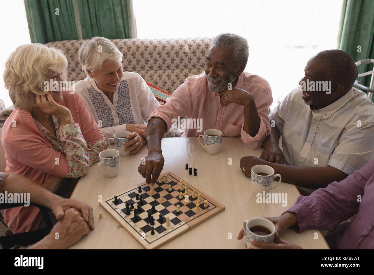 Gruppe von älteren Menschen Schach spielen im Wohnzimmer Stockfoto