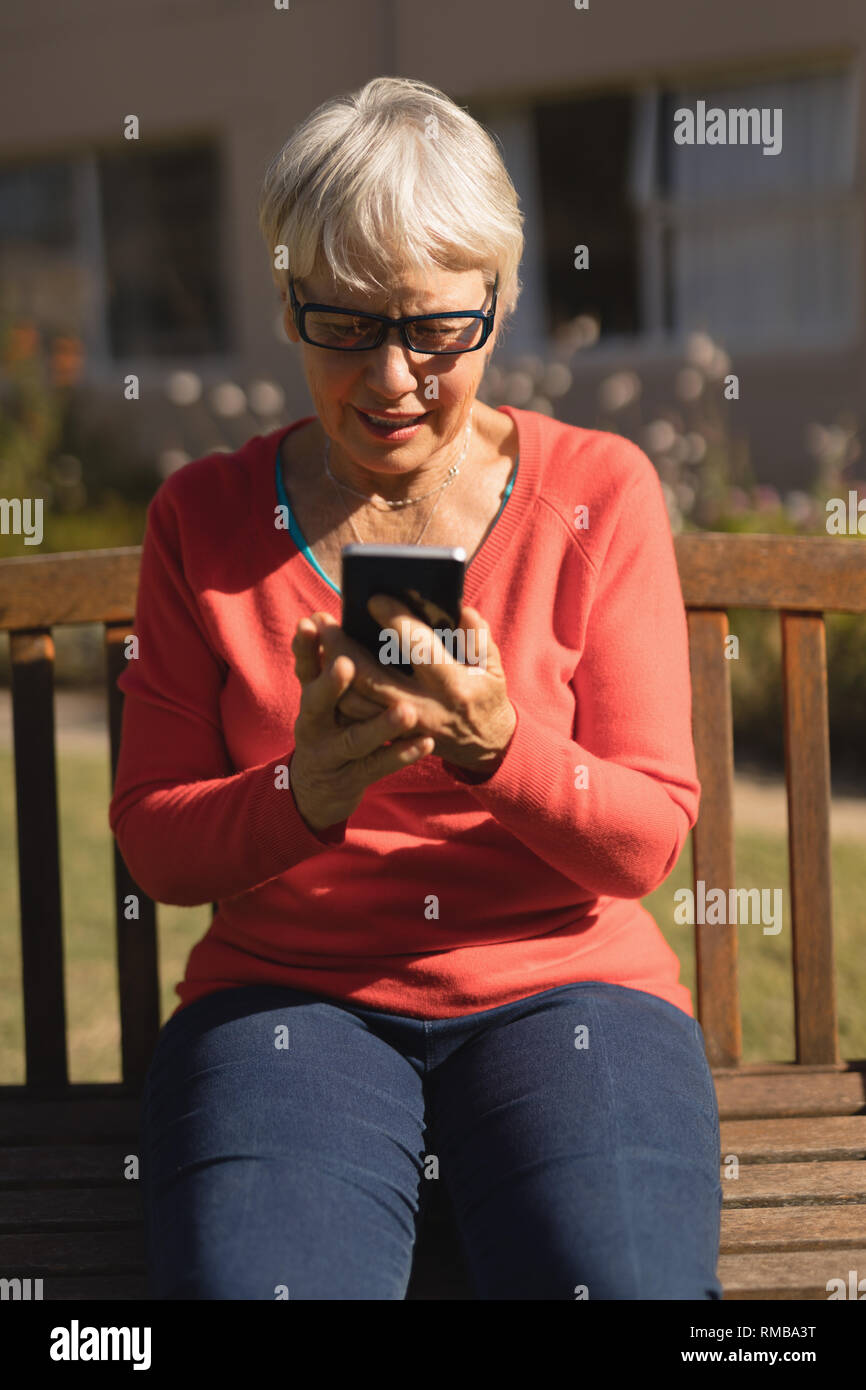 Ältere Frau mit Handy im Park Stockfoto