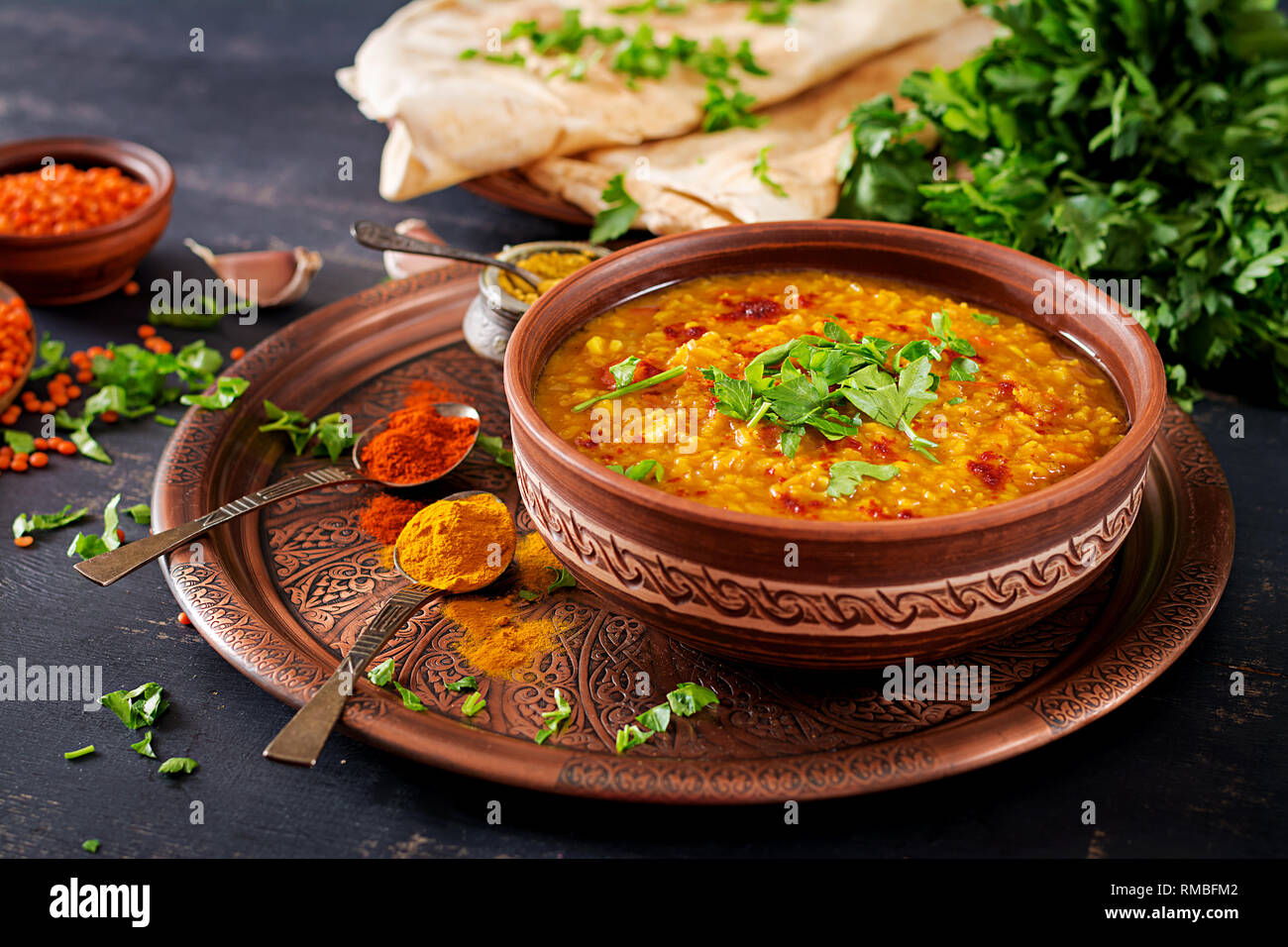 Indisches Dal. Traditionelle indische Suppe Linsen. Indische Dhal spicy Curry in der Schüssel, Gewürze, Kräuter, rustikale schwarz Holz- Hintergrund. Authentische indische Gericht. O Stockfoto