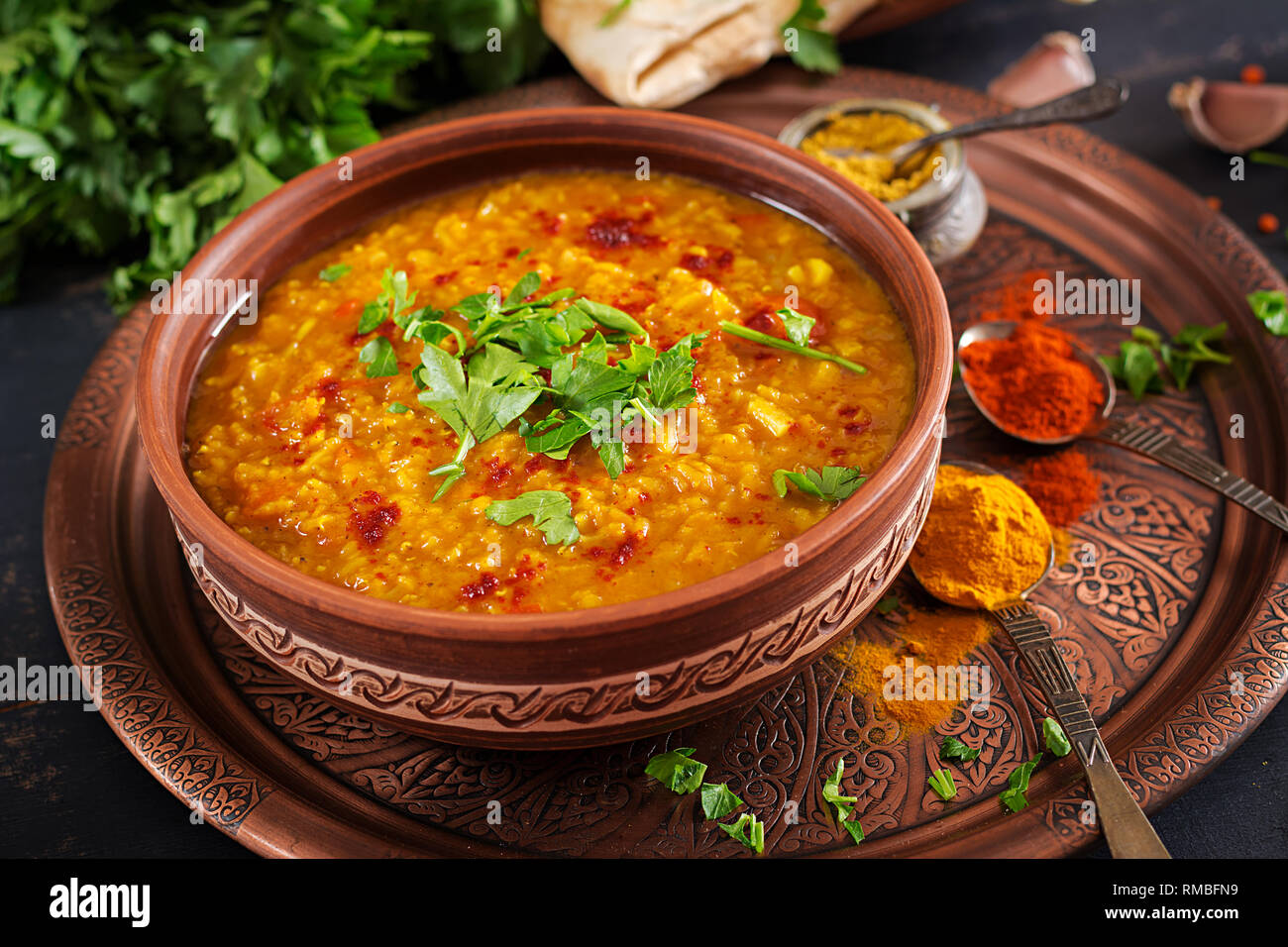 Indisches Dal. Traditionelle indische Suppe Linsen. Indische Dhal spicy Curry in der Schüssel, Gewürze, Kräuter, rustikale schwarz Holz- Hintergrund. Authentische indische Gericht. O Stockfoto