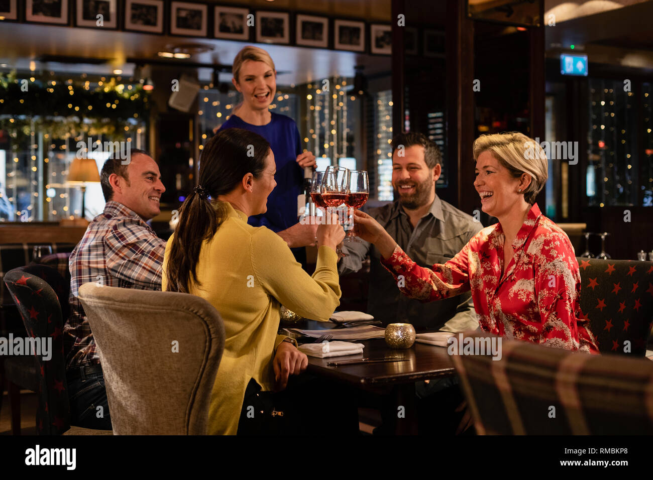 Zwei ältere Ehepaare eine feierliche Toast mit einem Glas Rose Wein, während in einem Restaurant sitzen. Stockfoto