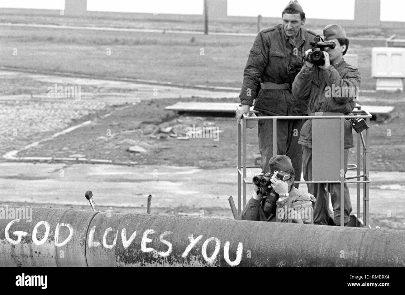 Mitglieder der DDR-Grenztruppen beobachten und dokumentieren einer Bereitstellung der West-Berliner Polizei gegen die Insassen des sogenannten Lenne Dreiecke am Potsdamer Platz. Ende Mai 1988, mehrere hundert Personen besetzt ein Standort in unmittelbarer Nähe der Mauer gegen den Bau einer Autobahn zu protestieren. In der Folge gab es immer wieder Konflikte mit der Polizei. Stockfoto