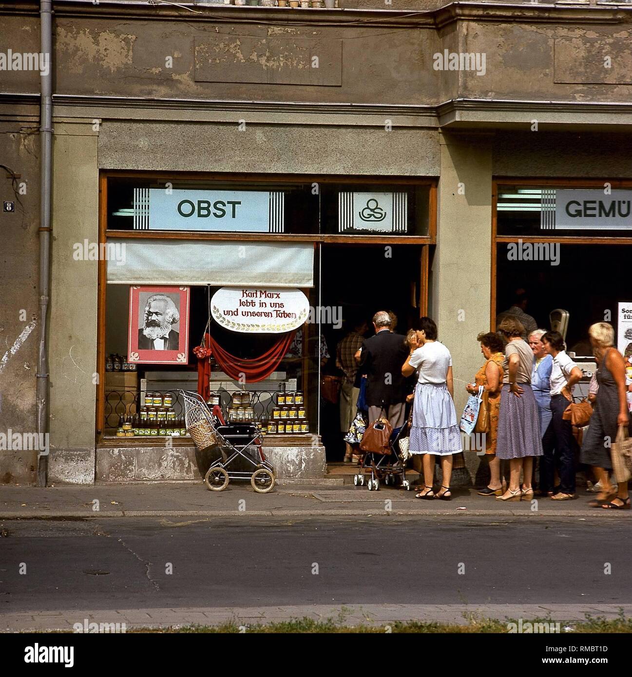 Die Leute Schlange vor einem Gemüse shop in Weimar, wo anlässlich der Karl Marx, ein Porträt dieser Sozialistischen im Schaufenster hängt. Stockfoto
