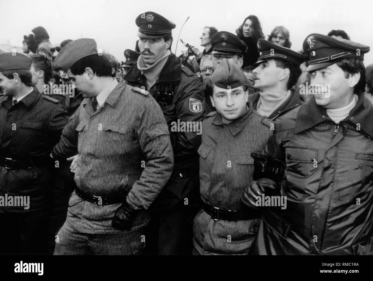 Eine Gruppe von Grenzsoldaten der DDR und Mitglieder der West-Berliner Polizei zusammen kommen nach dem Fall der Mauer. Stockfoto