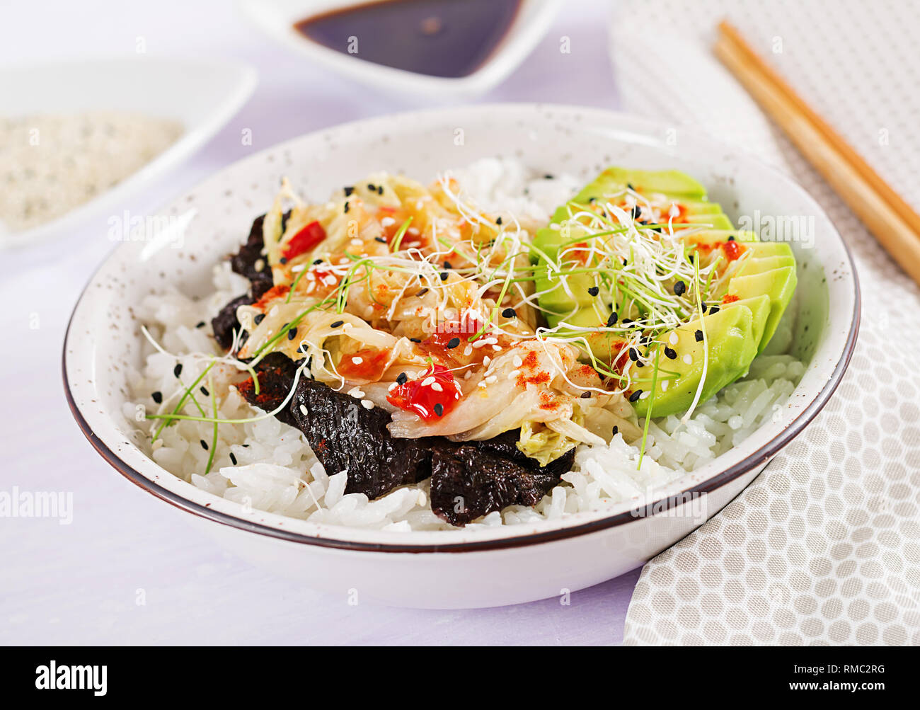 Vegan Salat mit Reis, eingelegte Kimchi Kohl, Avocado, Nori und Sesam auf die Schüssel. Sushi-food-Hybriden Trend. Gemeinkosten Stockfoto