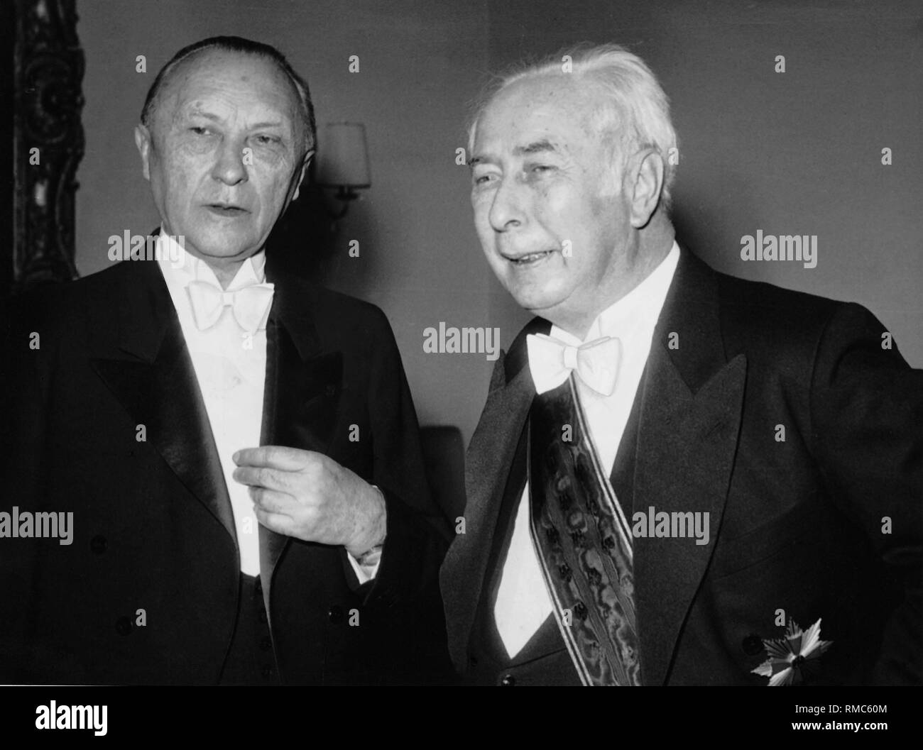 Bundespräsident Theodor Heuss, hier trägt einen Flügel und eine Medaille, in einem Gespräch mit Bundeskanzler Konrad Adenauer bei seinem Neujahrsempfang. Stockfoto