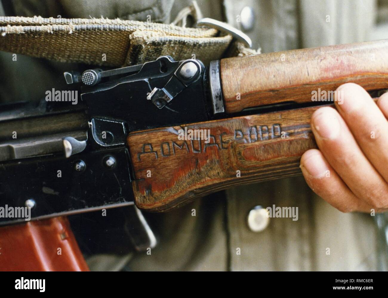 Ein Kämpfer hält seine AK-47 Kalaschnikow in der Kamera in ein Lager auf pakistanischem Territorium. Kyrillische Zeichen sind klar erkennbar auf die Waffe - es war während des Kampfes erobert. Stockfoto