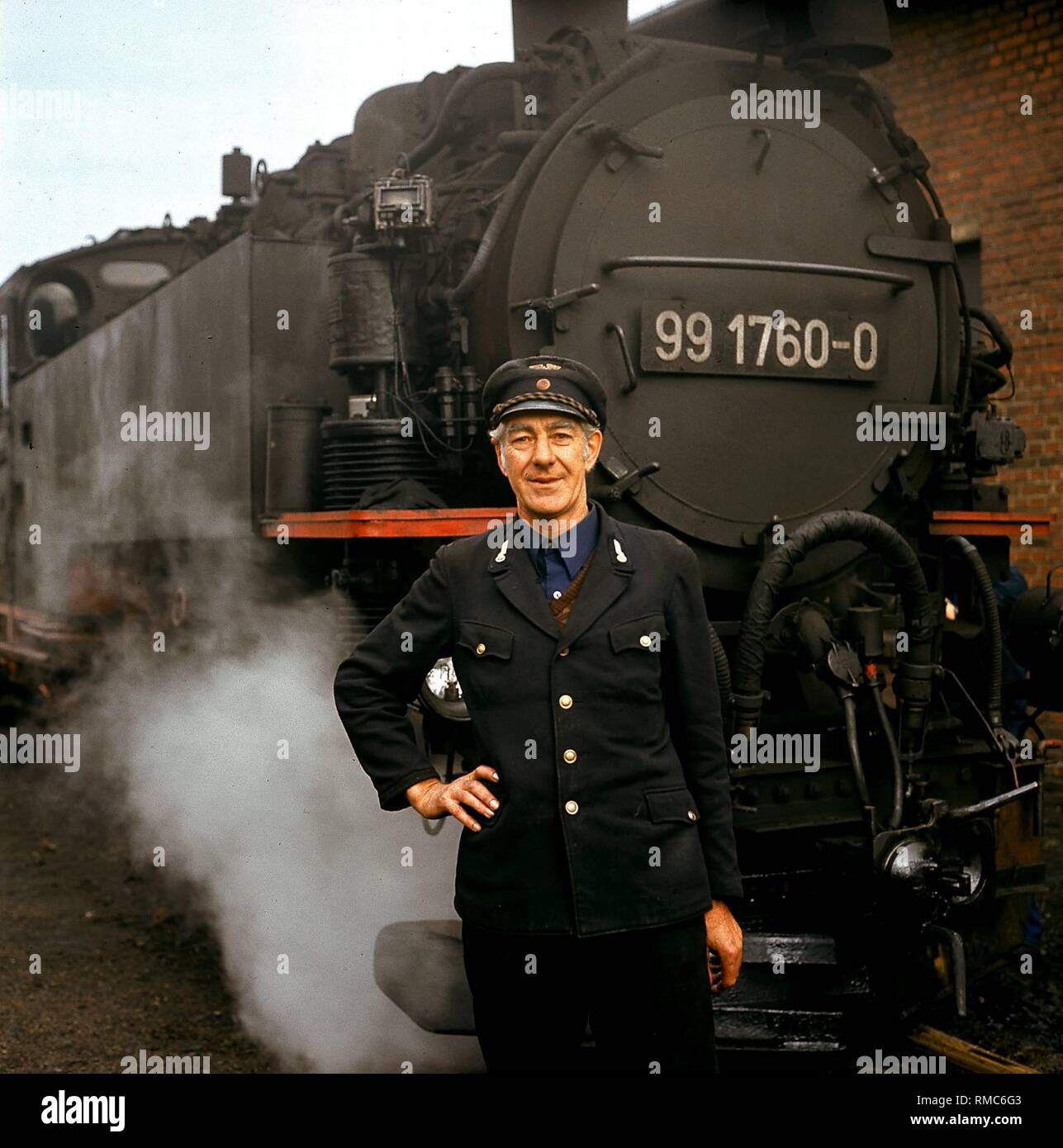 Ein Mitglied des Personals der Eisenbahnen vor einer Dampflokomotive der Deutschen Reichsbahn in Zittau. Stockfoto