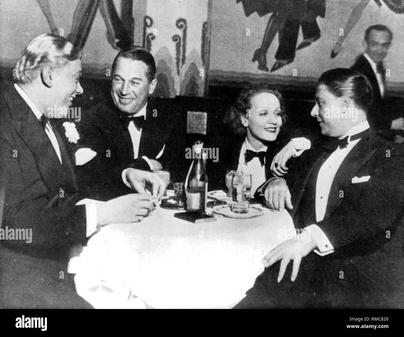 Der französische chansonnier Maurice Chevalier, der Schauspielerin Marlene Dietrich und ihr Mann Rudolf Sieber in der Bar "New Yorker" in Hollywood (1933). Stockfoto