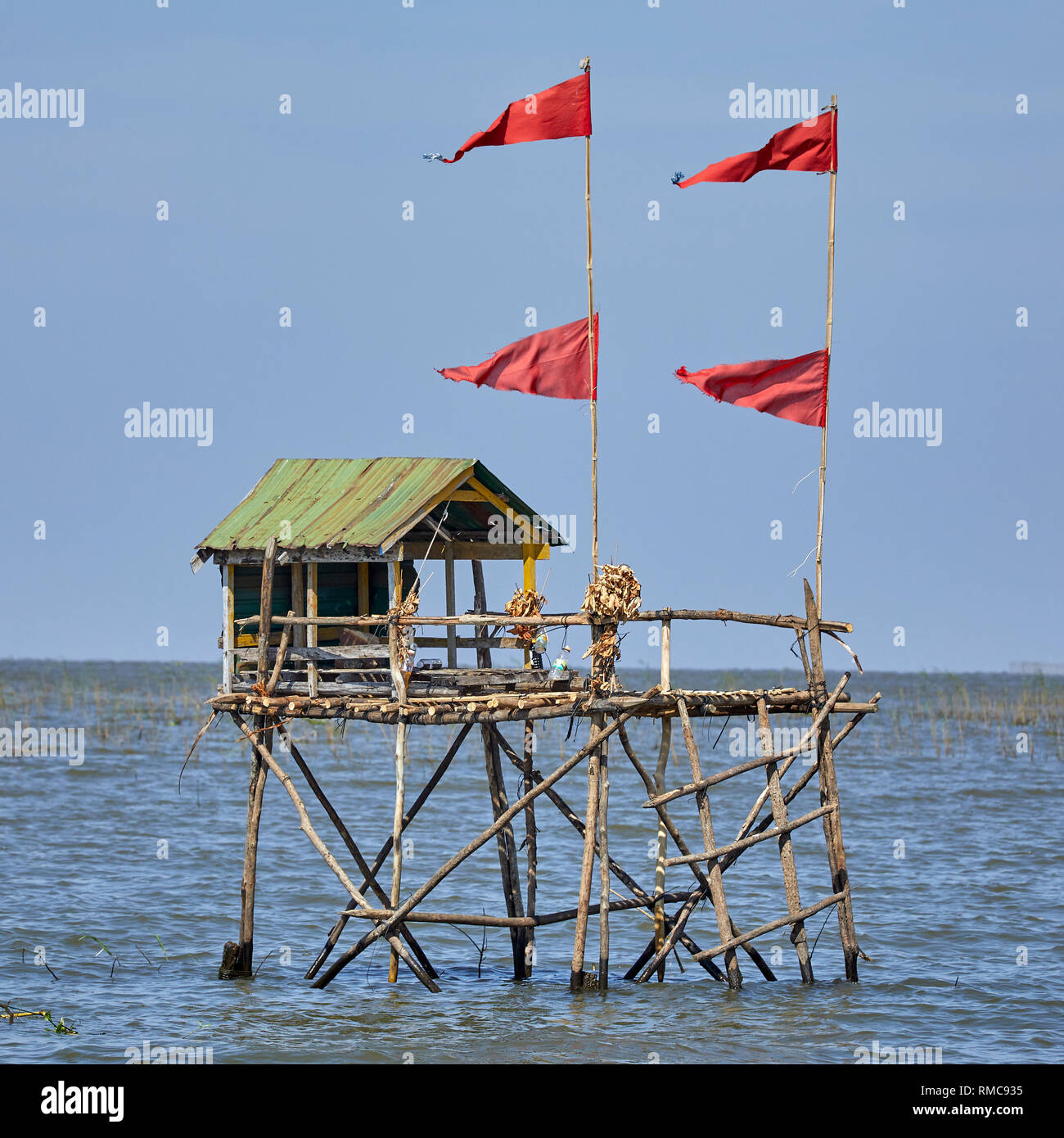 Tonlé Sap See, Kambodscha. 18. Dezember, 2017. Ein Geist Haus auf hölzernen Pfählen in den See mit Flags flying bringt Glück auf Fischer. Stockfoto