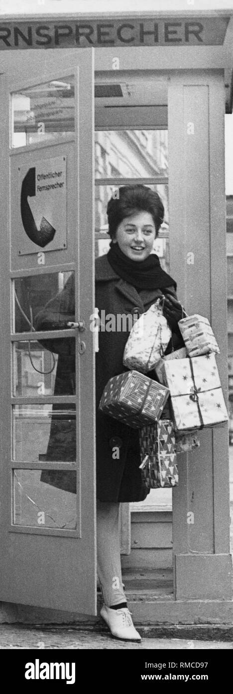 Frau, die weihnachtspakete hinterlässt eine Telefonzelle, 50 s Stockfoto