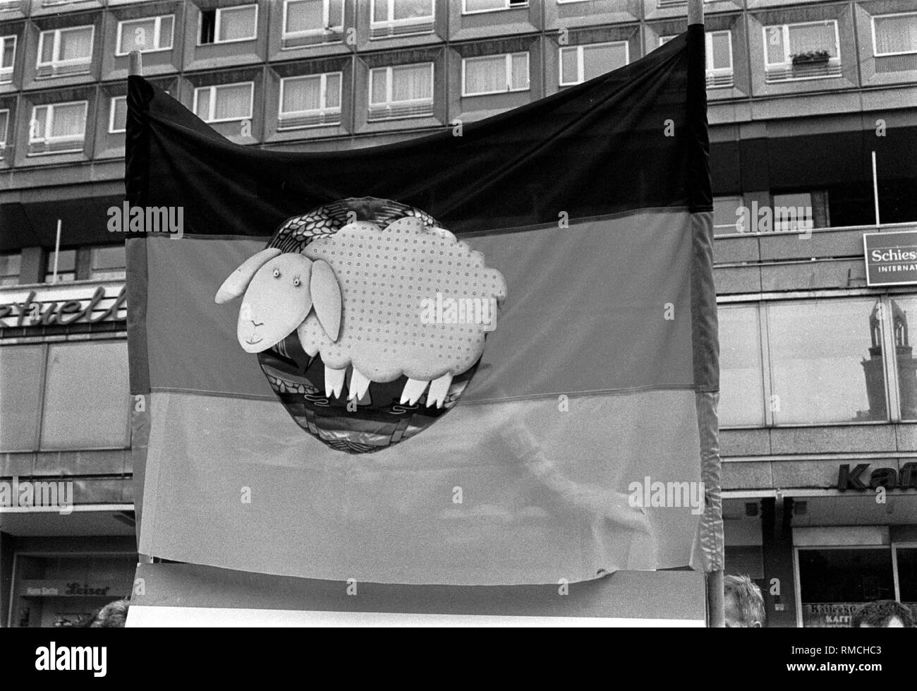Deutschland, Berlin, 31. Juli 1990: DDR Fahne mit "Ossi-Schaf", einige Demonstration am Alexanderplatz, Berlin-Mitte. Stockfoto