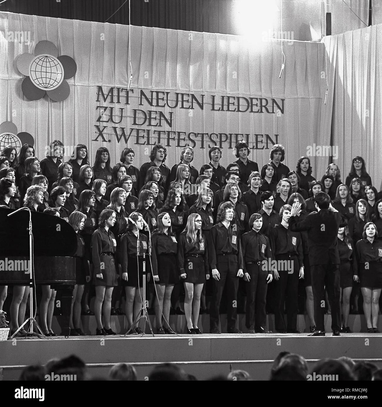 Ein Chor der Freien Deutschen Jugend (FDJ), hinter der die Inschrift "mit den neuen Songs, die auf X. Welt Festival" in Erfurt. Stockfoto