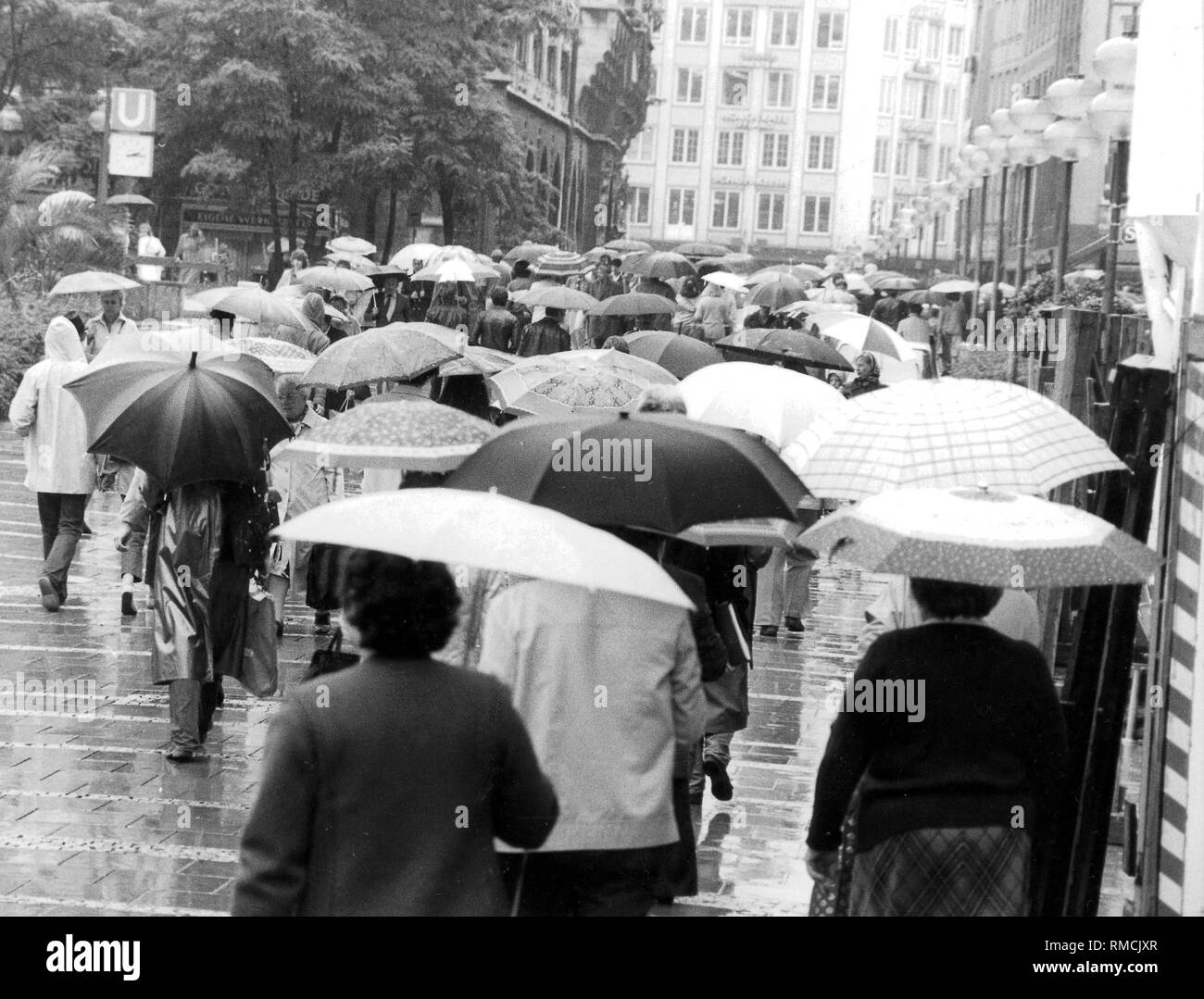 Regnerische Wetter in München, Fußgänger mit Sonnenschirmen in der Weinstrasse. Stockfoto