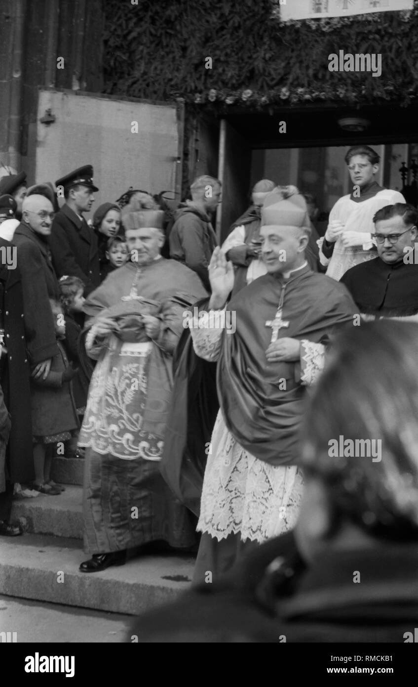Auf der linken Seite, Aloysius Muench, Erzbischof und Apostolischer Nuntius in Deutschland, auf der rechten Seite thront der neue Erzbischof von München und Freising, die Kirche verlassen, die von Servern. Stockfoto