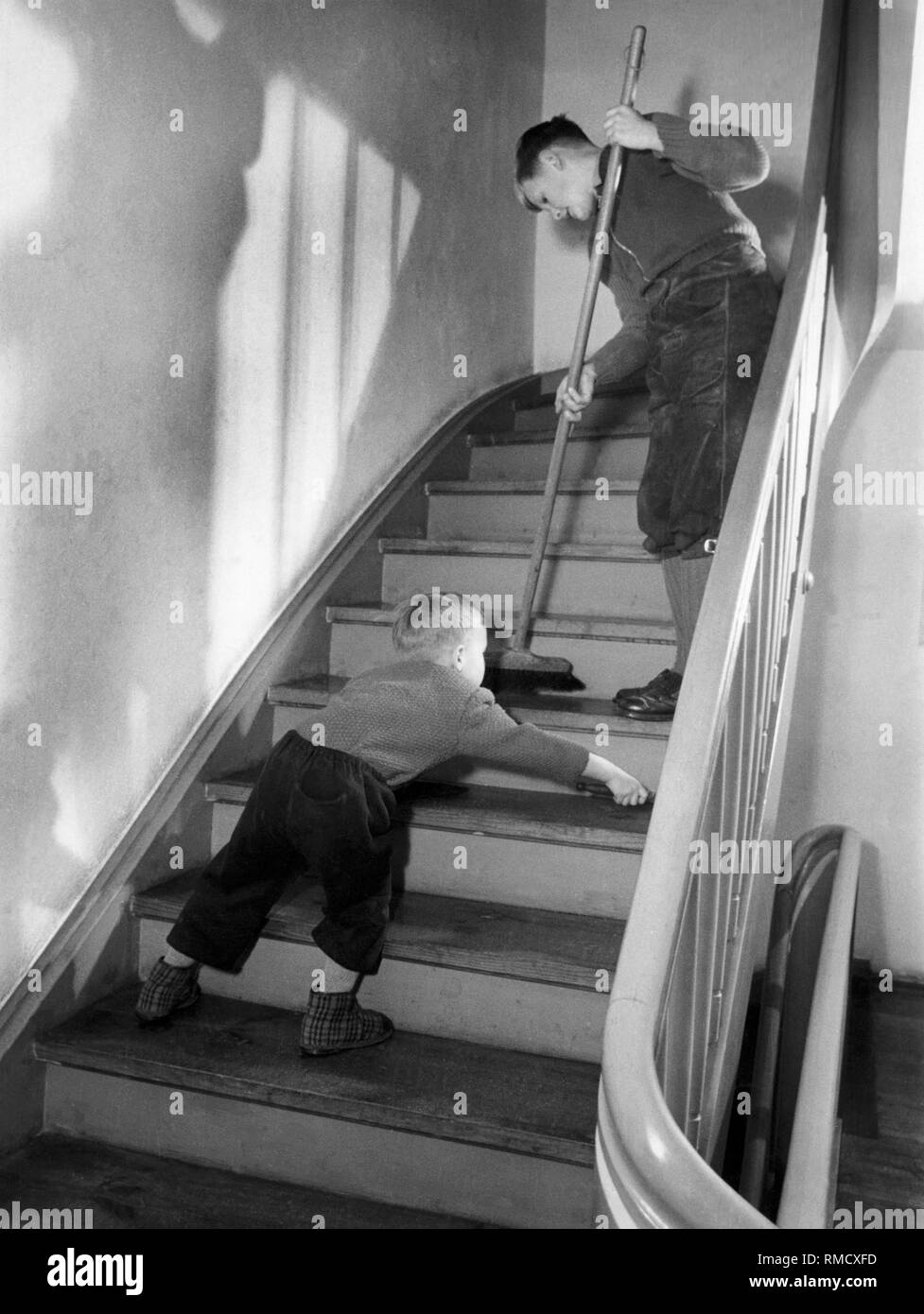 Zwei Jungen, die Hausarbeit zu tun, 50 s Stockfoto