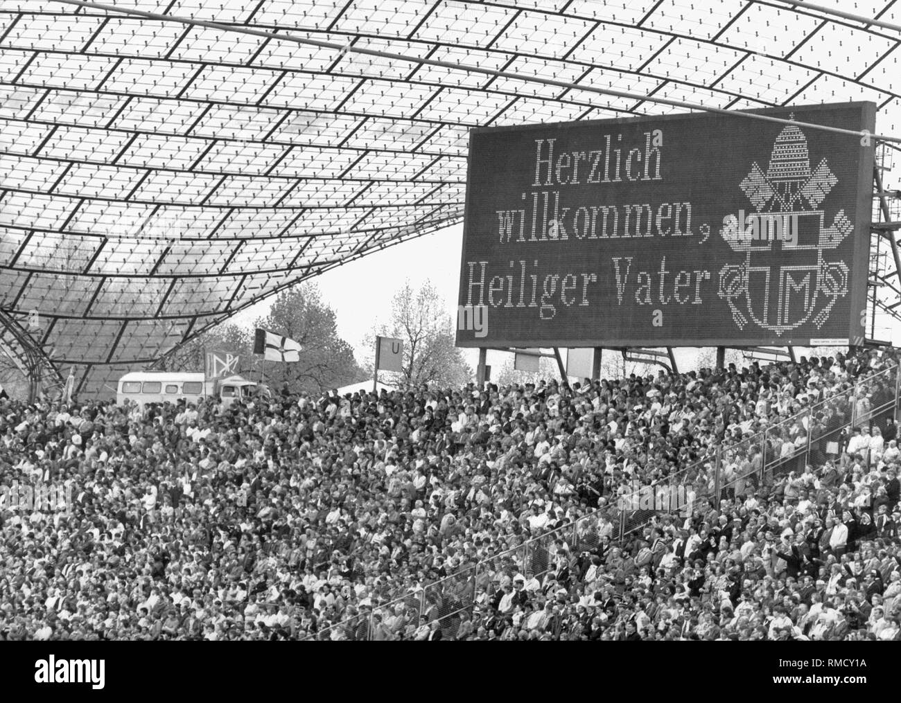 Bei seinem zweiten Besuch in Deutschland, Papst Johannes Paul II seliggesprochen der Jesuitenpater Rupert Mayer, der von den Nazis verfolgt worden war, im Olympiastadion München. Auf der Anzeigetafel (englische Übersetzung) "Heiligen Vater" willkommen. Stockfoto