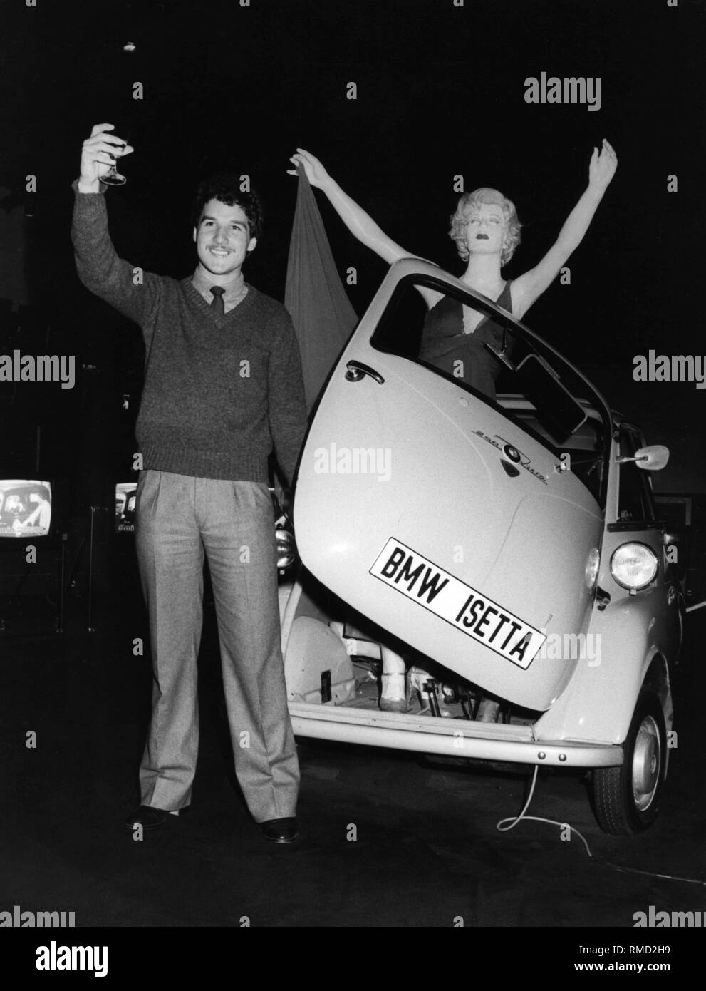 Der 23-jährige Oskar Wegemann aus Südtirol gewann ein Fahrer schulung mit der finnischer Rallyefahrer Rauno Aaltonen in einem BMW 323i, als er den 500.000sten Besucher der Ausstellung "zeitsignale" ("Signale") an das BMW-Museum. Hier Wegemann vor einem BMW Isetta mit einem ausgestellten Marylin Monroe Abbildung. Stockfoto