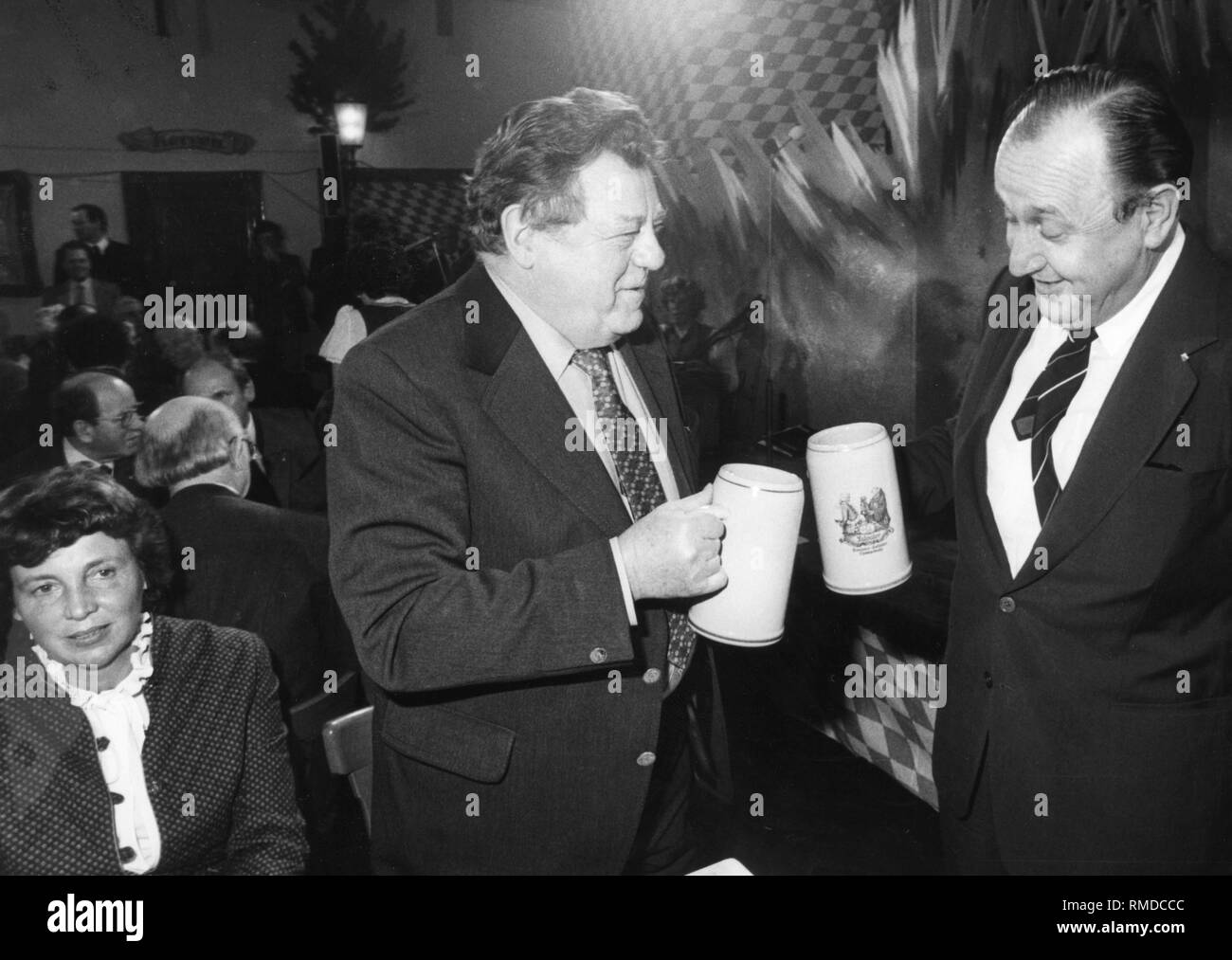 Der bayerische Ministerpraesident und CSU-Chef Franz Josef Strauß clinks Gläser mit Bundesaußenminister und Parteichef der FDP Hans-Dietrich Genscher an der Salvator-probe am Nockherberg in München. Auf der linken Seite sitzt Marianne Strauss. Stockfoto