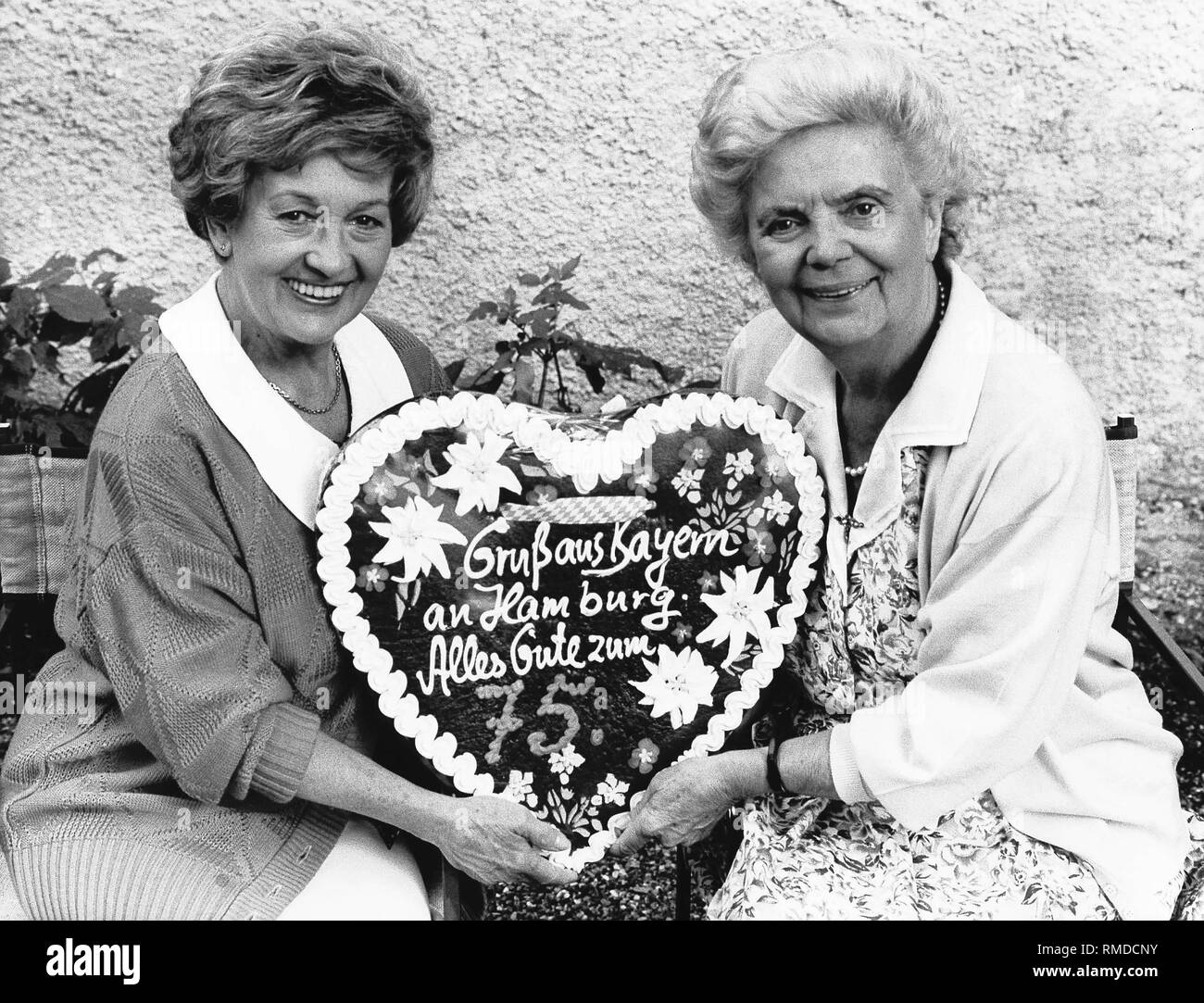 Die Schauspielerinnen Erni Singerl und Heidi Kabel mit einem Lebkuchenherz anlässlich von Heidis Kabel zum 75. Geburtstag. Stockfoto