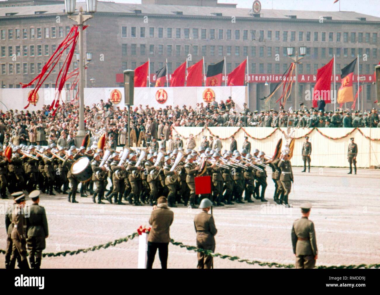 Militärische Zeremoniell am militärischen Parade der Nationalen Volksarmee (NVA) am 1. Mai 1959 an dem Marx-Engels-Platz in Berlin Ost, im Hintergrund das Haus des ZK der SED am Werderschen Markt links mit dem Emblem der SED. Stockfoto