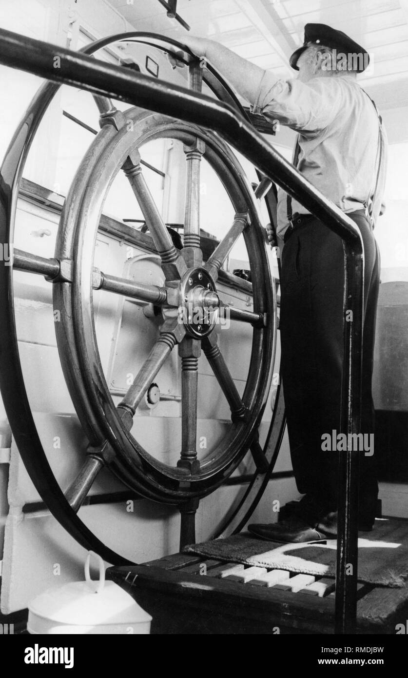 Ein Steuermann am Ruder Segeln mit der Fähre Von Meersburg nach Konstanz. Stockfoto