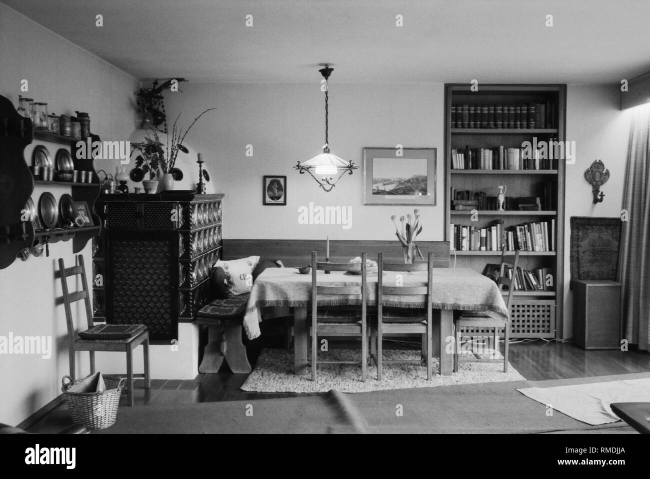 Innenausbau einer Wohnung in Murnau mit einem Kachelofen, Esstisch, Bücherregal, Bilder, etc. Stockfoto