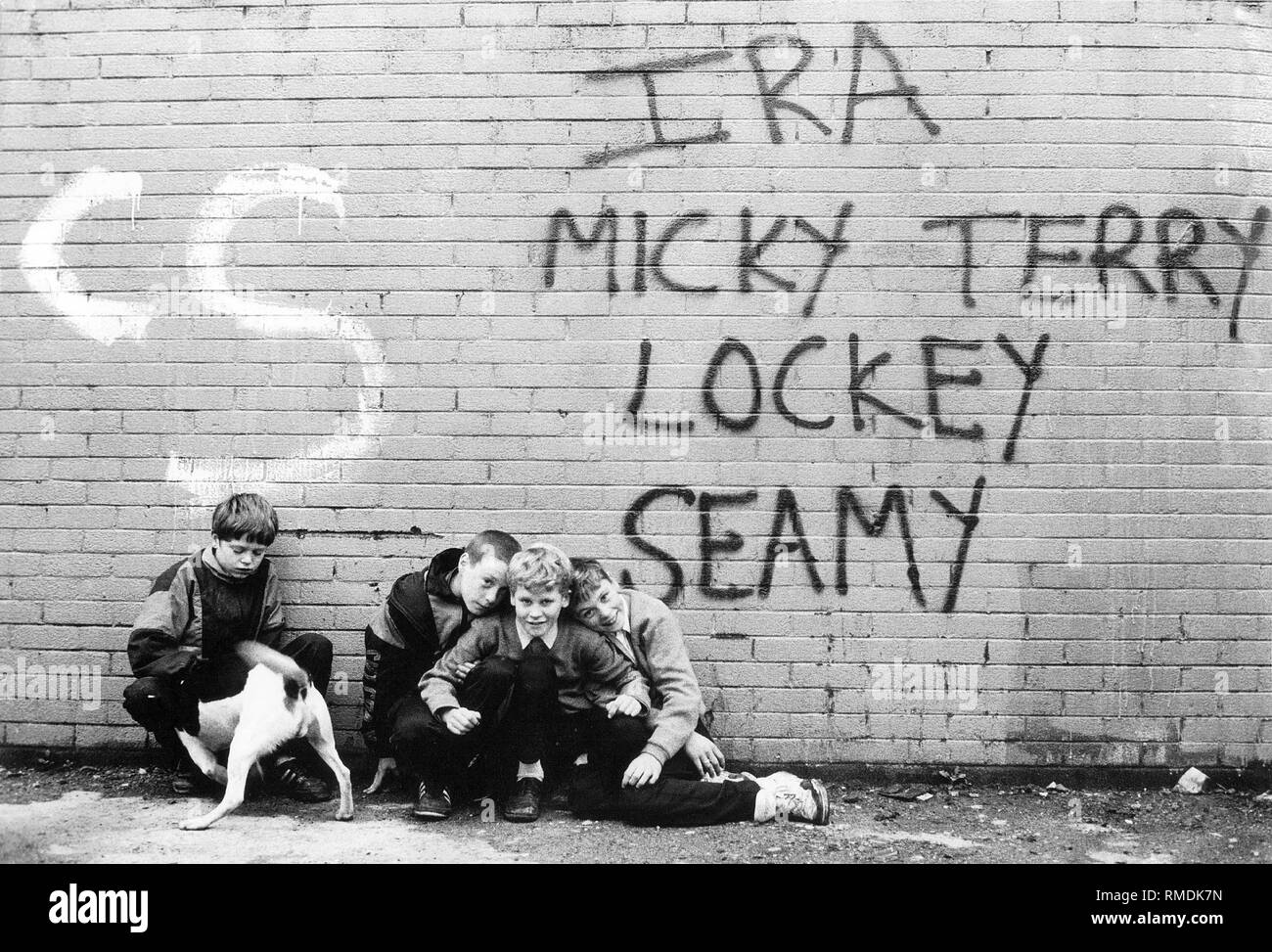 Kinder im 'Frieden', eine Wand, die durch Belfast läuft Katholiken und Protestanten voneinander zu trennen. Die Kinder sind hier auf der katholischen Seite. Stockfoto