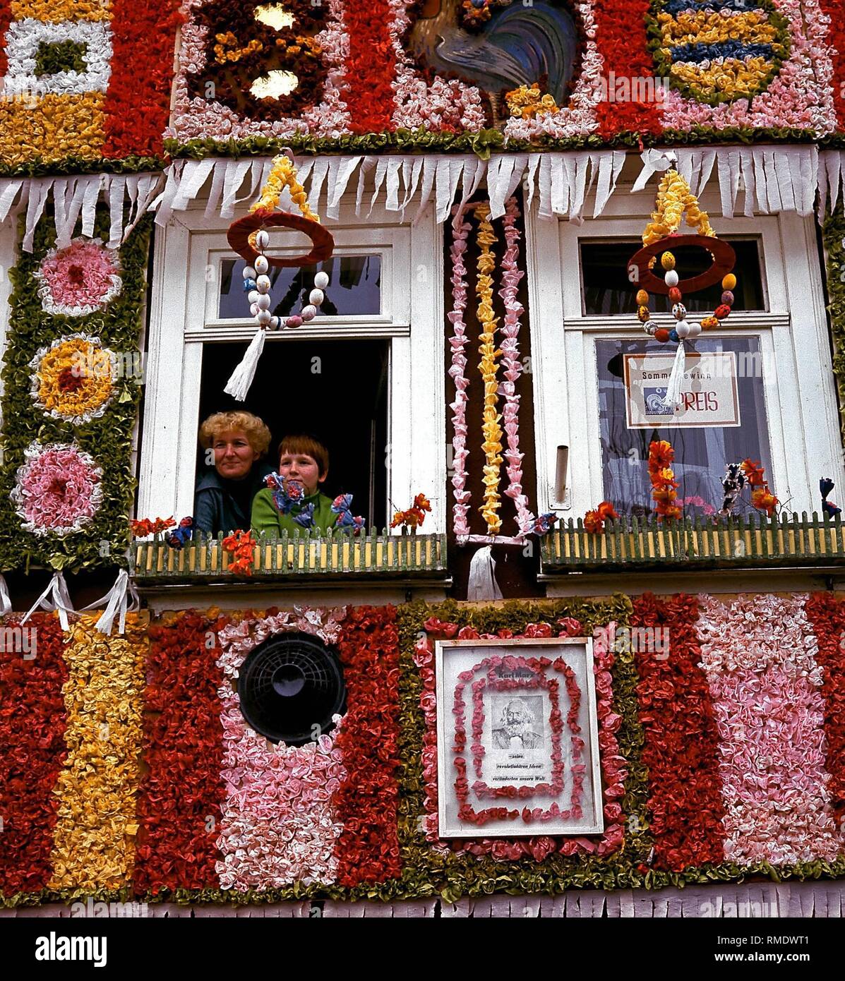 Bürger von Eisenach haben ihre Häuser mit Blumen für die sommergewinn, das traditionelle Frühlingsfest mit einer großen Parade eingerichtet. Unter dem Fenster ist ein Porträt von Karl Marx. Stockfoto