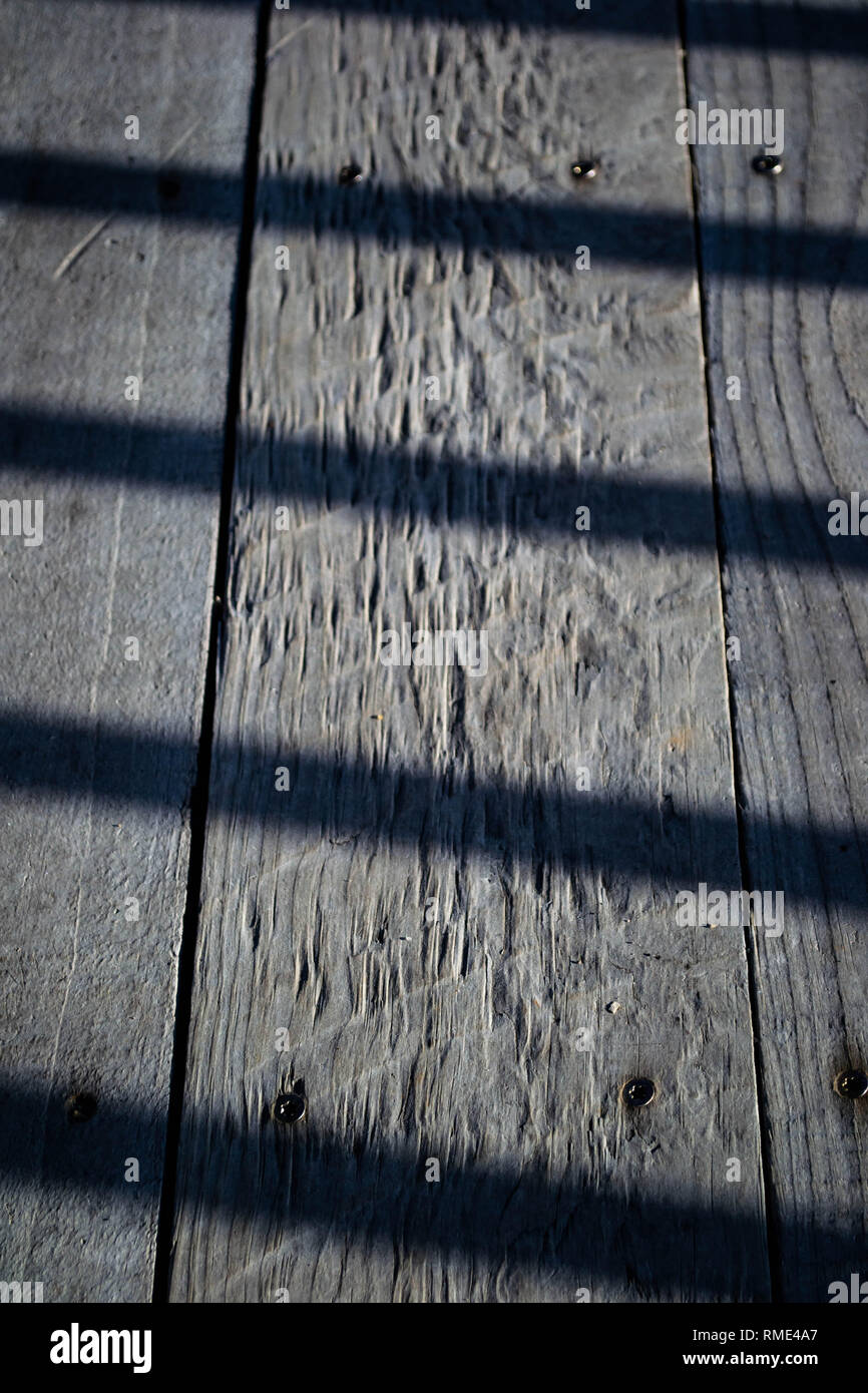 Schatten der Kreuzung alte verwitterte Holz- deck Boards. Stockfoto