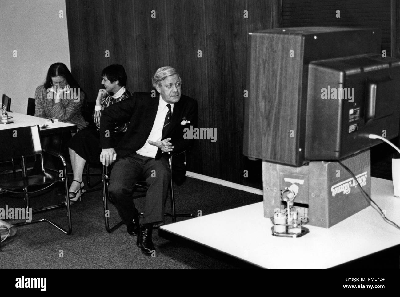 Der ehemalige Bundeskanzler Helmut Schmidt sieht an ein Fernsehgerät auf ein Bier Kasten von Koenig Pilsener (undatiert). Stockfoto
