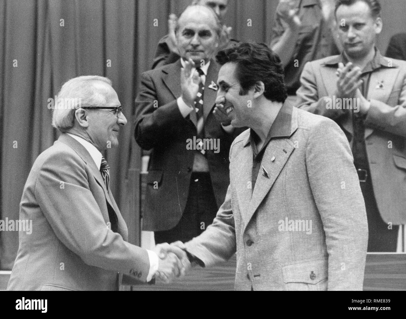 Erich Honecker gratuliert Egon Krenz zur Wiederwahl als Vorsitzender der DDR-Jugendorganisation FDJ in der 10. dem Parlament der FDJ Anfang Juni 1976 im Palast der Republik im Osten von Berlin. Stockfoto