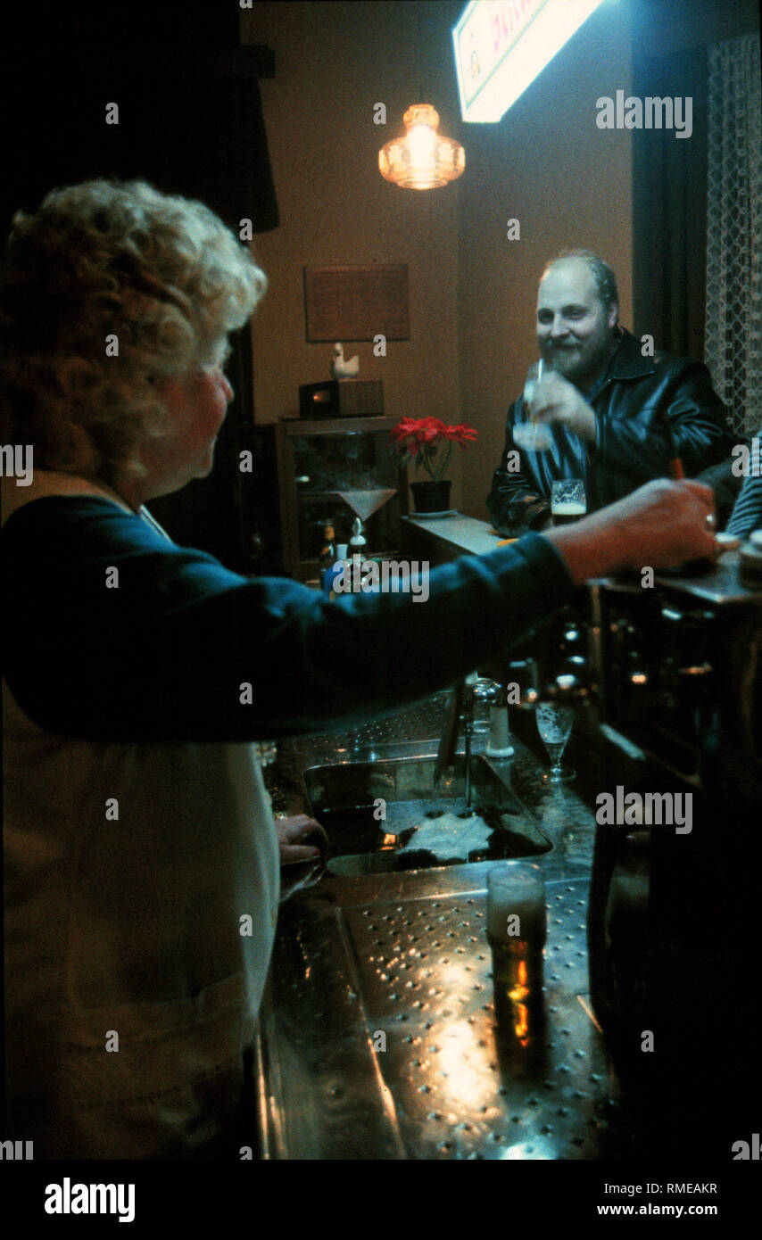 Berlin-Prenzlauer Berg, Deutschland, 02.11.1990, die Kneipe "Zum Wasserturm" Gastgeberin und Gast (biertrinker) an der Bar, nach der Wende die alte Gäste nicht mehr Geld hatte ein Bier in der Kneipe zu leisten, der Pub ist bald schließen und wieder von den jungen Menschen als Szene pub eröffnet. Stockfoto