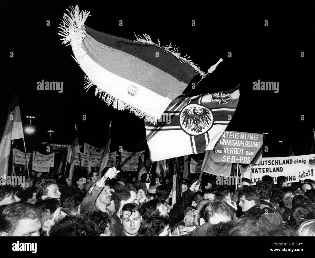 Anhänger der rechtsextremistischen Gruppen an einem Montag Demonstration im Zentrum von Leipzig wave Deutsche Fahnen und die 'Enteignung Nachfrage, gezwungen, Auflösung und Verbot" der SED-PDS. Stockfoto