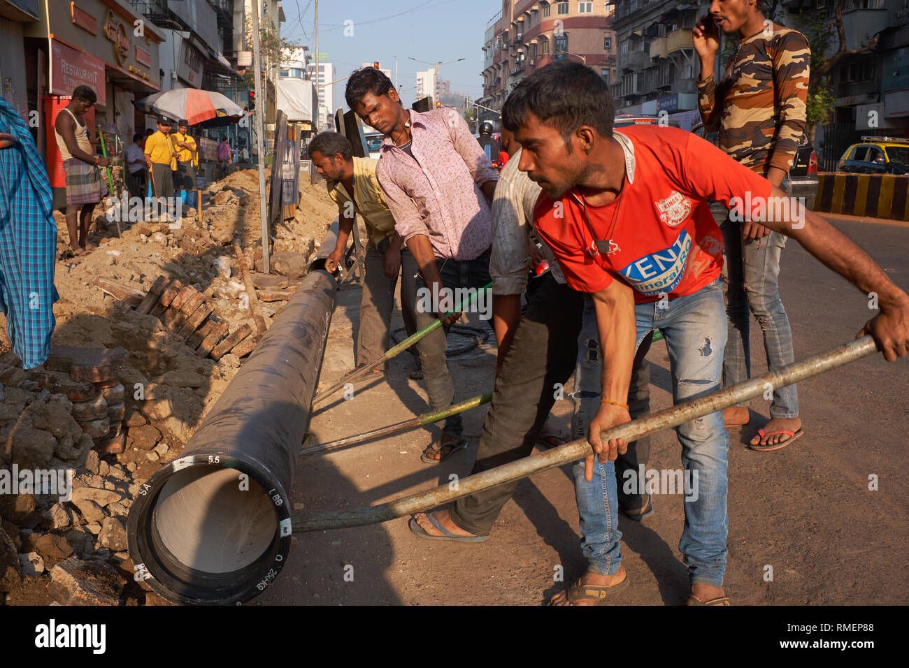 In den reichen Bereich der Girgaum, in der Nähe von Chowpatty Beach, Mumbai, Indien, Arbeiter benutzen die grundlegenden Tools öffnen Sie den Fußweg zu zerreißen & neue Wasserleitungen verlegen Stockfoto