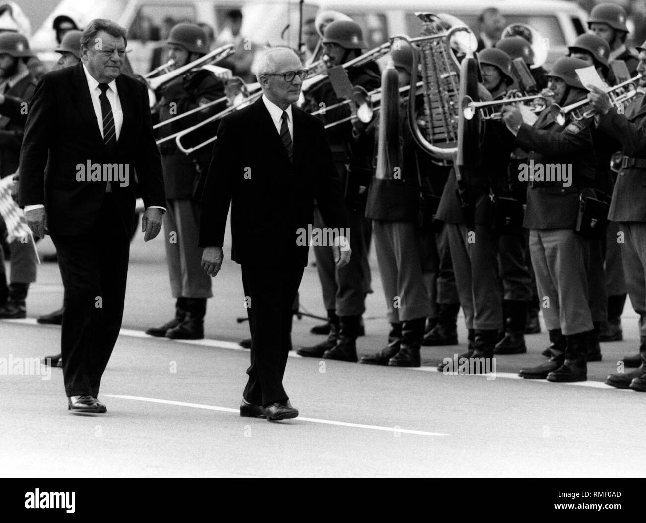 Der bayerische Ministerpräsident Franz Joseph Strauss erhält der Vorsitzende der DDR, Erich Honecker an der München-riem Flughafen. Im Hintergrund Polizisten sind Musik machen. Stockfoto