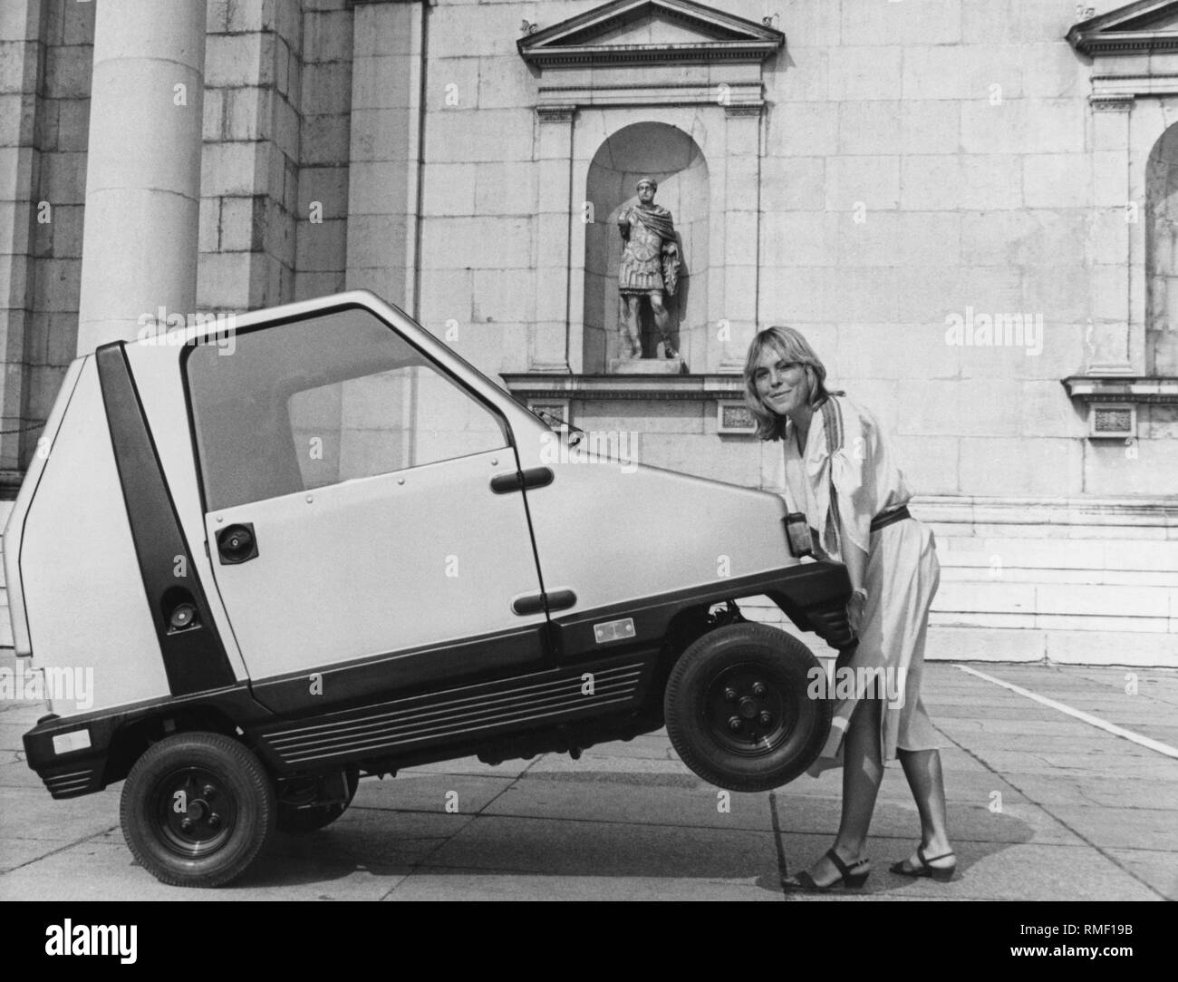 Eine Frau wirft die Vorderräder des "Cityboy". Die Micro Car des Herstellers 'MW Kleinwagen" ist von einem 3 angetrieben. s PS starken Zweitakter und erreicht eine maximale Geschwindigkeit von 25 km/h. Stockfoto