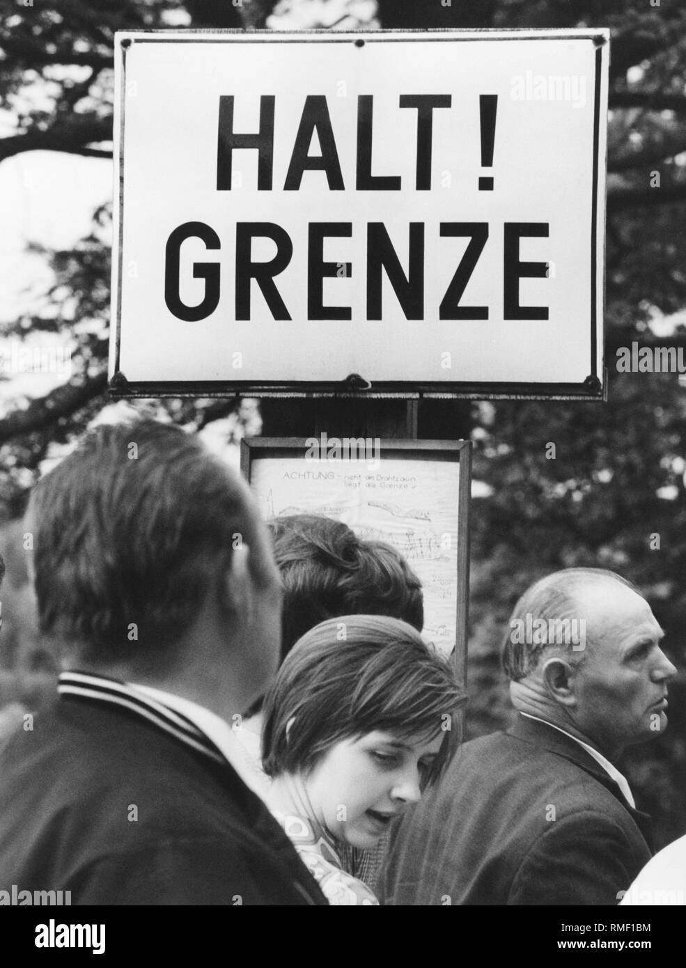 Leute, die vor ein Warnschild an der innerdeutschen Grenze, etwa 1980. Stockfoto