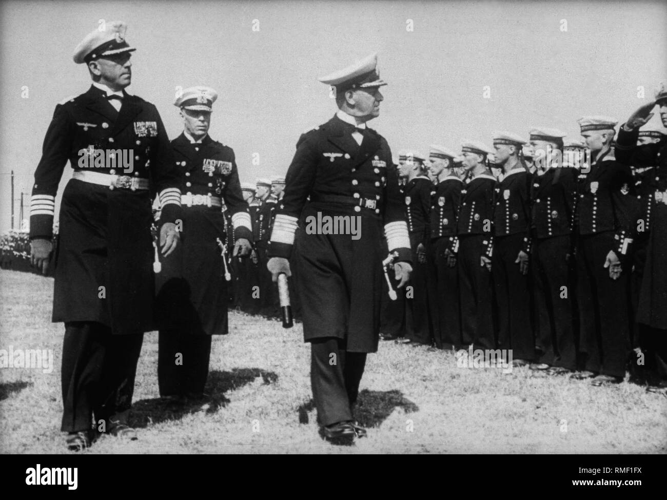 Grand Admiral Erich Raeder (rechts) und Kapitän Otto Ciliax (links), der Kommandant der deutsche Kreuzer "Admiral Scheer" während der Mission der Legion Condor (Nordsee Gruppe), prüfen Sie die marine Truppen der "Admiral Scheer". Stockfoto