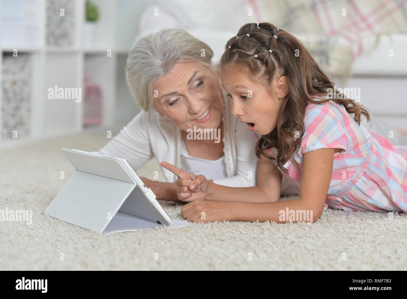 Portrait von nettes Mädchen mit Großmutter mit Tablet Stockfoto
