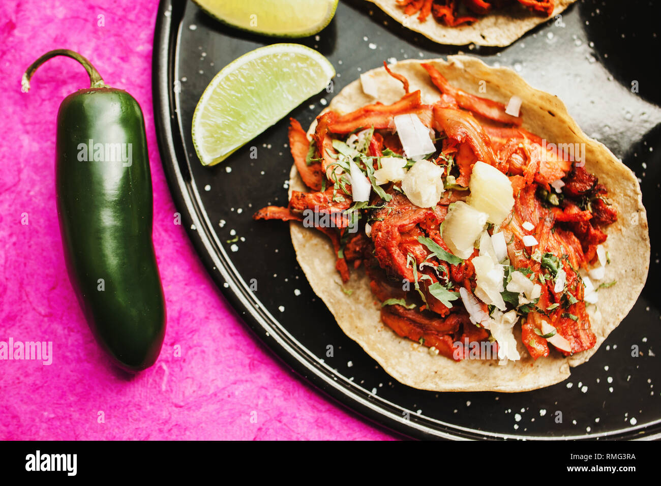 Pfeffer und Kalk in der Nähe von Tacos al Pastor und Saucen Stockfoto